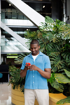 Man Typing on Smartphone in Green Space