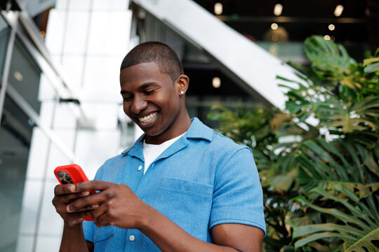 Businessman Smiling While Typing on Phone