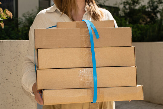 Delivery person carries multiple packages in a residential area