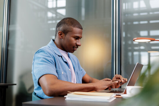 Man Working with Phone and Laptop at Work Desk