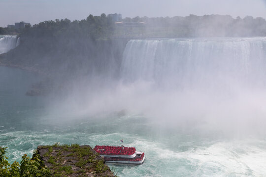 A Cruise Boat Lined with Tourists in Red Plastic Ponchos Disappearing into the Mist at Niagara Falls, Ontario, Canada
