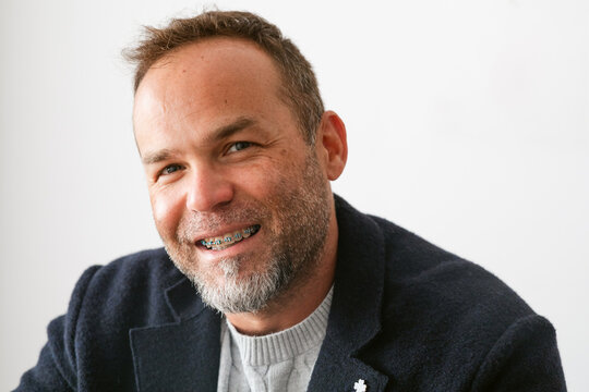 Smiling Man With Braces in Cozy Indoor Setting During the Day