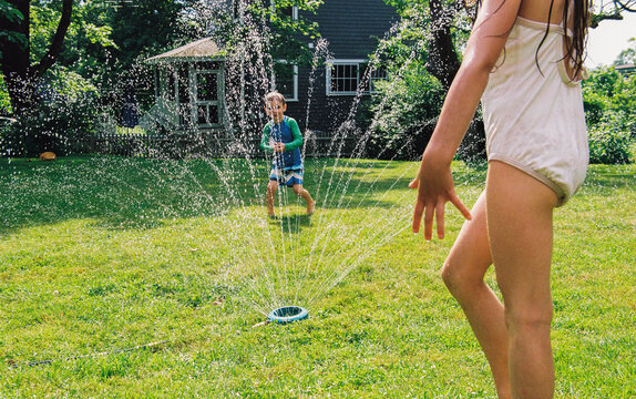 Children Playing With a Backyard Sprinkler
