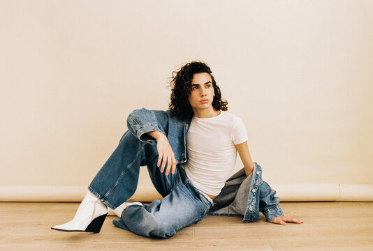 Queer man posing with denim clothes