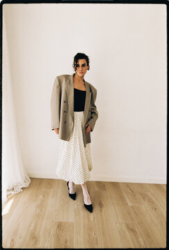 Man posing wearing oversized blazer and polka dot skirt