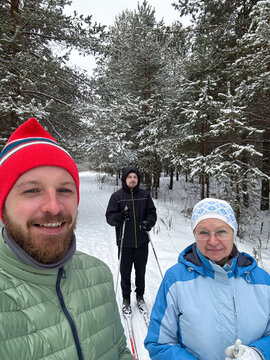 Group skiing selfie in snowy pine forest
