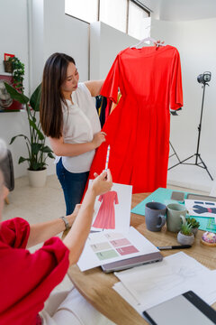 Fashion designers comparing a finished dress to its design 