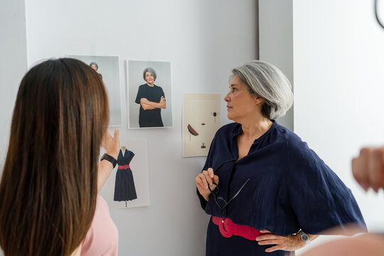 Fashion designers reviewing photos and sketches on a wall