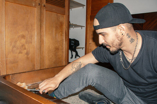 Man repairs furniture in a living room at home