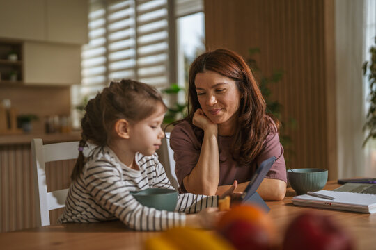 Mother and daughter learning with digital tablet at home