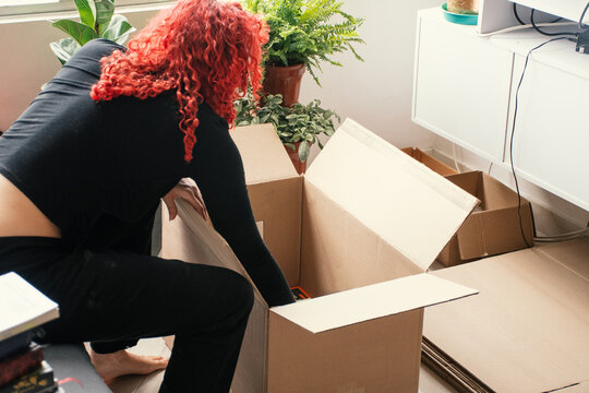 Packing belongings in a cozy living room with plants and boxes