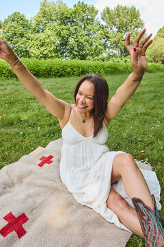 Beautiful black woman with a glass of champagne on a picnic blanket