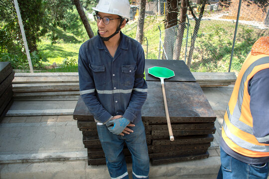 Construction worker smiling at job site during daylight hours