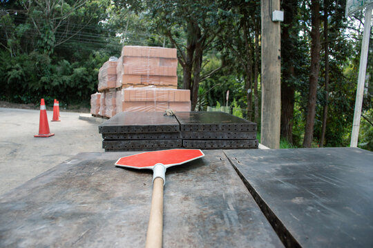 Construction site with stop sign and material stacks in daylight