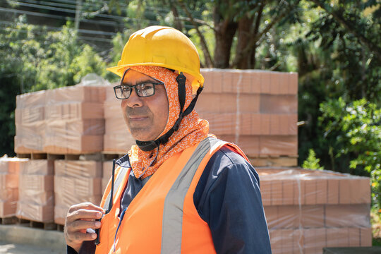 Construction worker in safety gear at building site during day