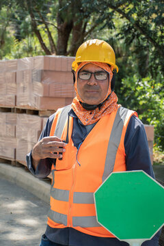 Construction worker directing traffic at a busy site in daylight