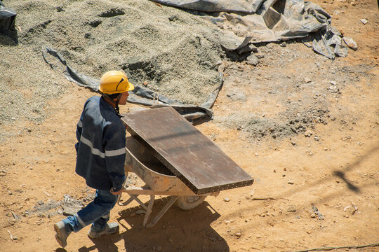 Construction worker moving wheelbarrow at building site