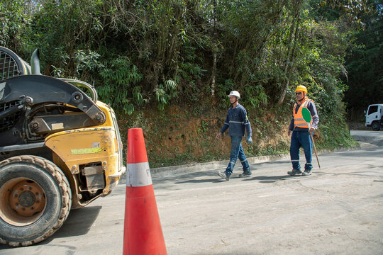 Construction workers assessing road conditions in a rural area