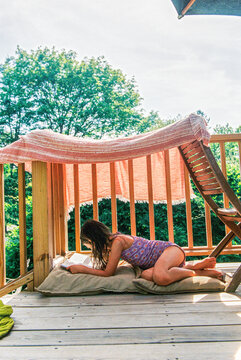Child Reading in makeshift tent on deck
