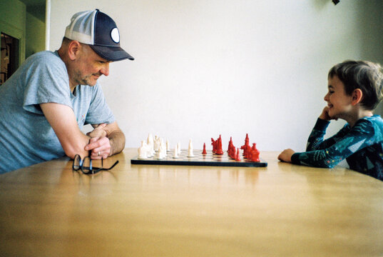 Father and son play chess together