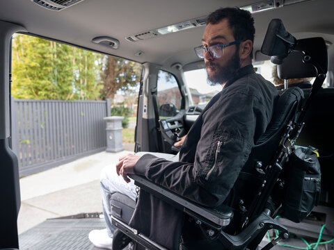 Man in Wheelchair Inside Accessible Vehicle Prepares to Exit