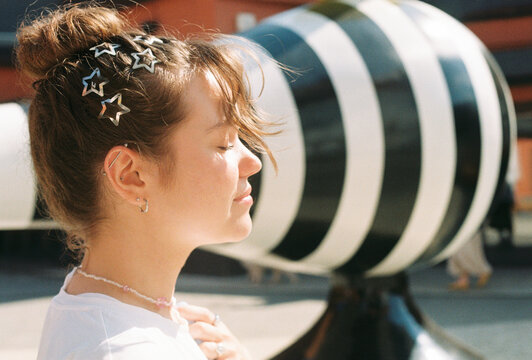 Young woman with star clips enjoying sunlight

