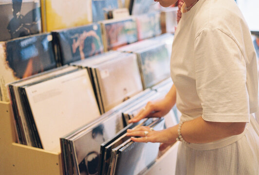 Woman browsing vinyl records in cozy shop
