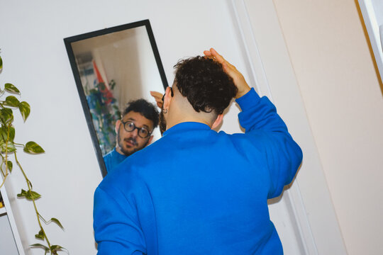 Man Fixing Hair in Mirror