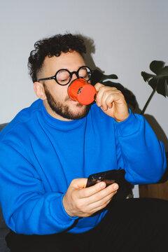 Man Drinking Coffee While Using Phone