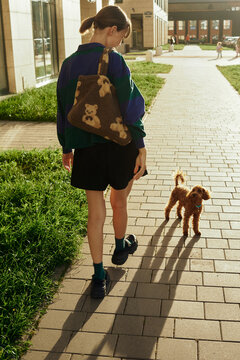 Woman walking with a dog during golden hour