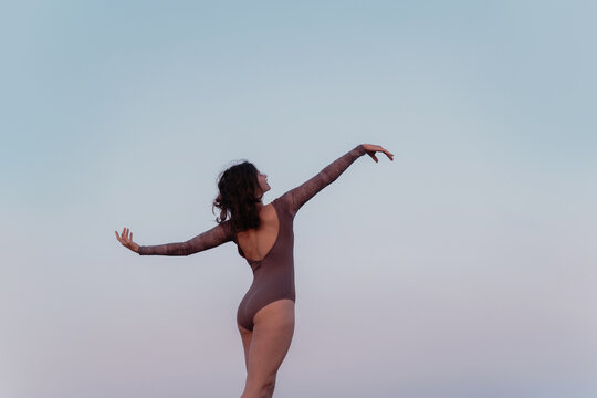 Dancer Expresses Freedom Under Sky at Dusk