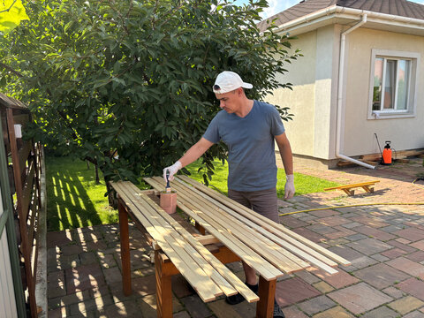 man paints boards