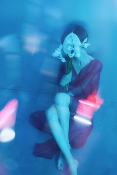 Neon light portrait of woman with flowers