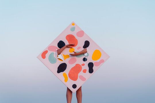 Hands Reaching out From a Colorful Abstract Art Canvas