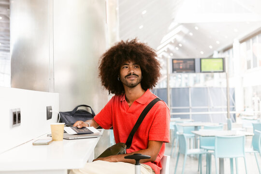 Young Man Working at a Modern Cafe With Laptop and Coffee
