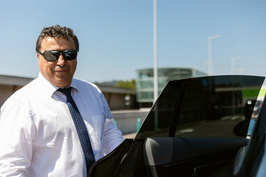Businessman Getting Into a Car on a Sunny Day at the Airport