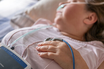 Patient undergoing clinical sleep study diagnostic sensors, woman sleeping with nasal cannula and pulse oximeter, medical monitoring apnea device, screening and treatment chronic sleep deprivation © kittyfly