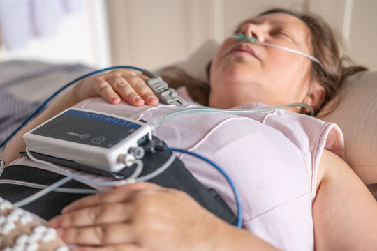 Woman resting in bed with home medical monitoring device, nasal cannula oxygen, Diagnostic procedure detecting apnea monitoring, pulse oximeter, quiet recovery, healthcare at home, calm resilience
