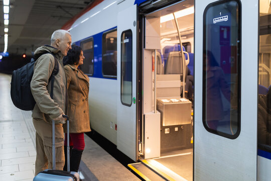 Mature couple waiting to board train at station platform