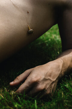 Man Resting on Grass With a Snail Slowly Moving on His Arm