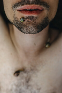 Unique Close-Up of a Man's Chin Adorned With a Snail Shell