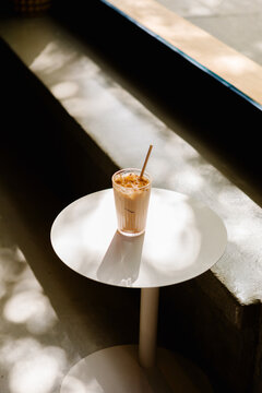 A chai latte on a small caf&eacute; table inside a modern specialty cafe