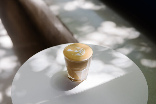 A latte decorated with latte art illuminated by sunlight