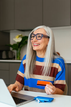 Delighted senior woman shopping online at home