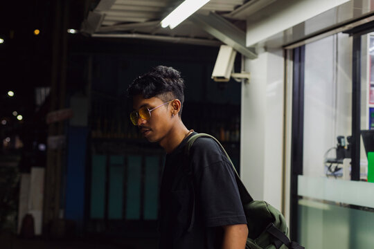 Night portrait of a young man in front of a convenience store
