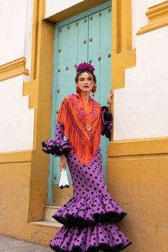 Festive portrait of woman in vibrant flamenco dress on city street