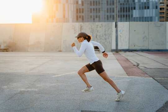 Athlete woman sprints at sunset