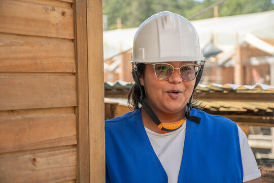 Woman in Safety Gear Explains Construction Work at a Site