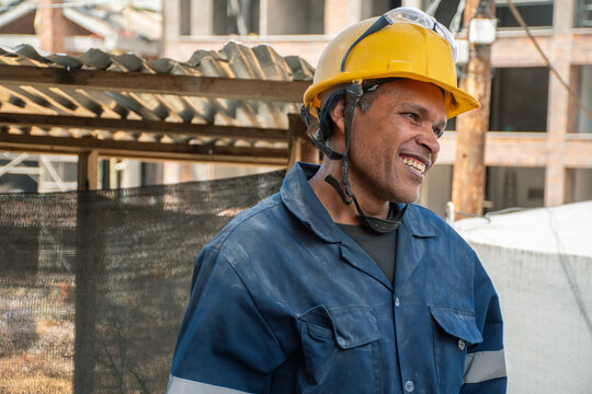 Construction Worker Smiles During Site Inspection at Busy Project