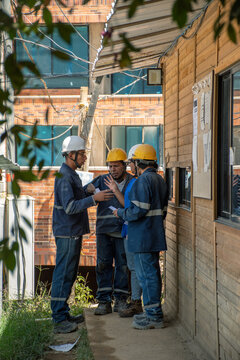 Construction Workers Discuss Project Details at Site in Daylight